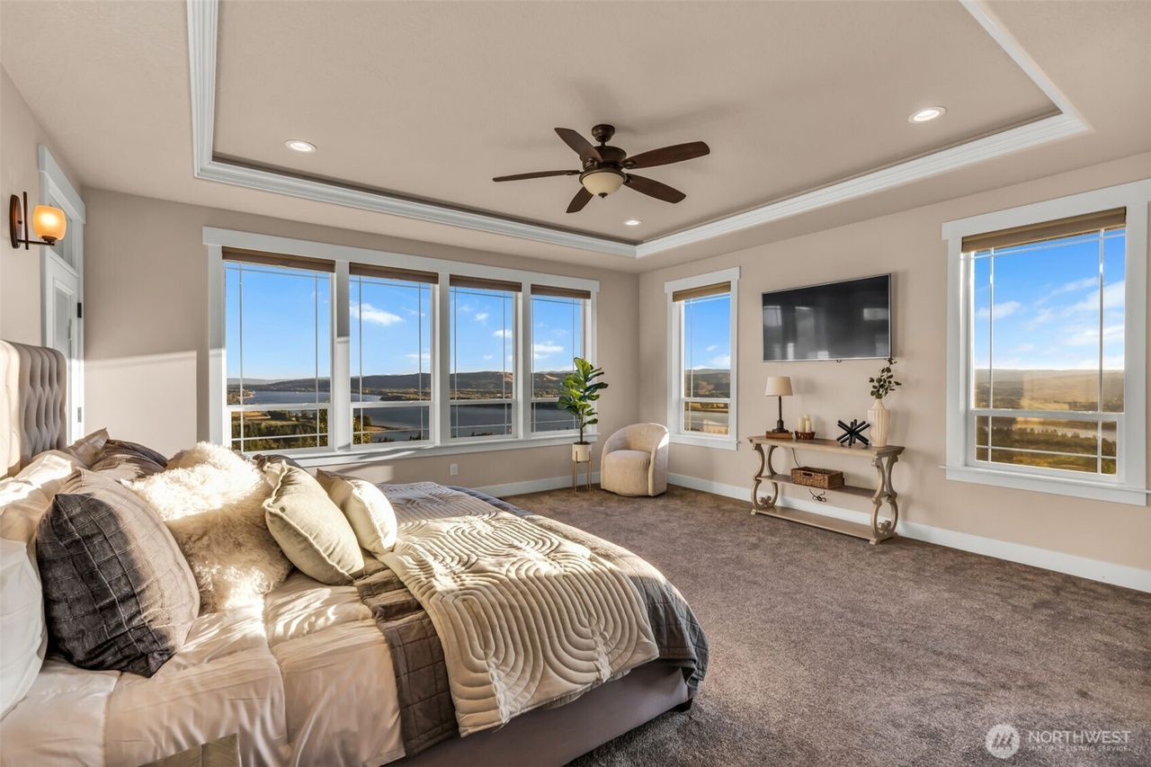 Main-level primary suite with wall of windows facing the valley